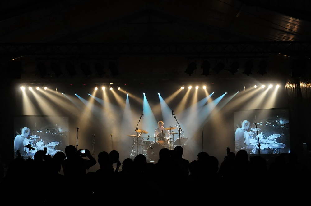 Bühne mit Publikum im Vordergrund, während Schlagzeuger ein Drumsolo spielt.