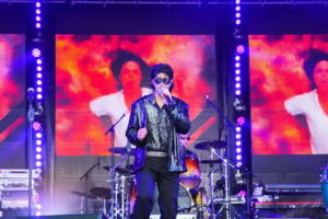 Sänger als Michael Jackson verkleidet auf der NDR Sommertour Bühne. Im Hintergrund Videoleinwände mit Bild von Michael Jackson